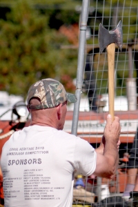 Both men and women entered the axe-throwing contest.  Here a man takes aim and is about to throw the axe toward the target.
