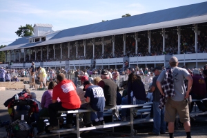 Both tiers of the grandstand are completely full, along with spectators watching on the ground.  The woodsmen's contests attract thousands of spectators.
